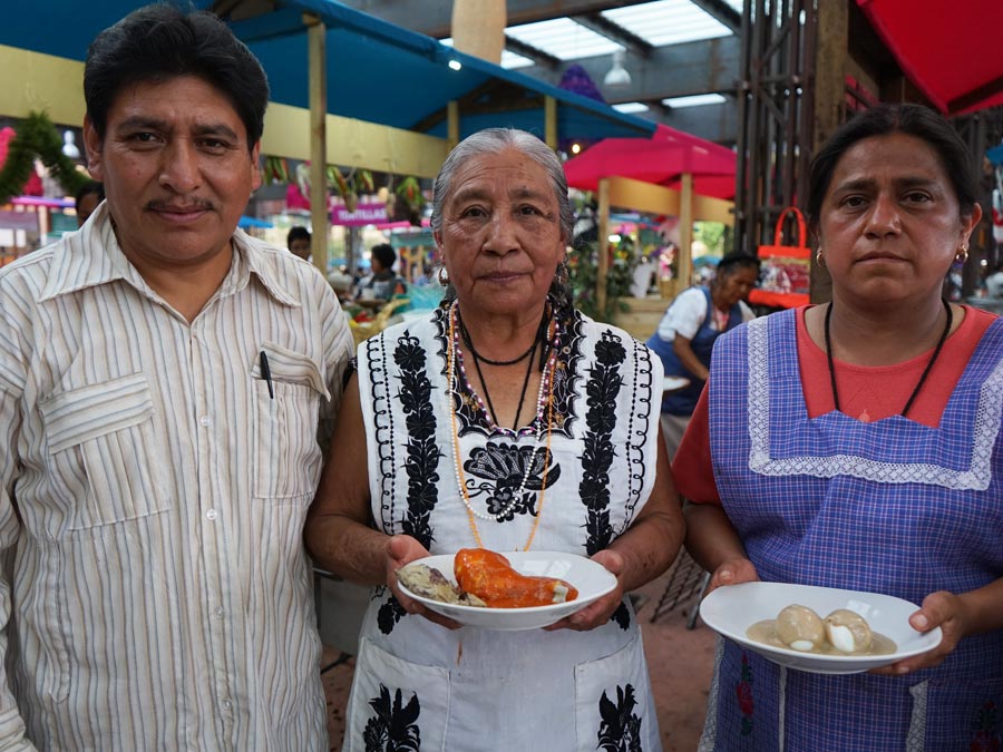 Beatriz Casimiro Martínez platica más sobre la comida de duelo (en medio). La acompañan su hijo y nuera Foto: Mariana Castillo